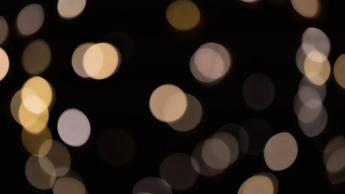 Colourful circular bokeh light spots scattered across a dark black background