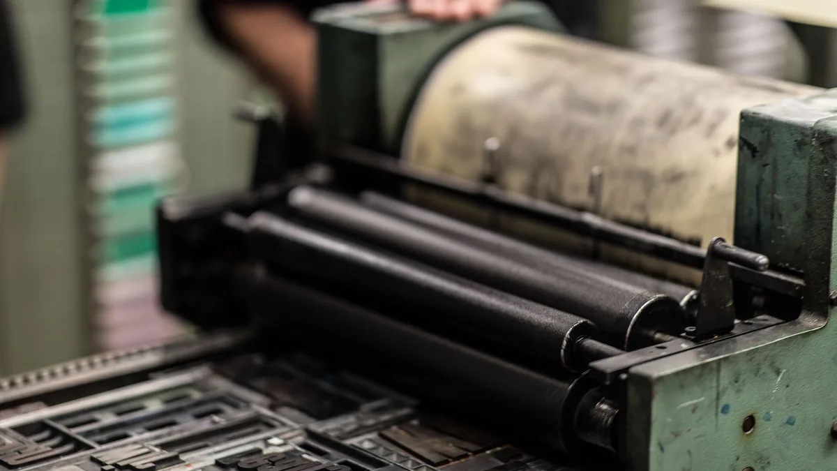 Close-up of the mechanism of an industrial printing press in green and black
