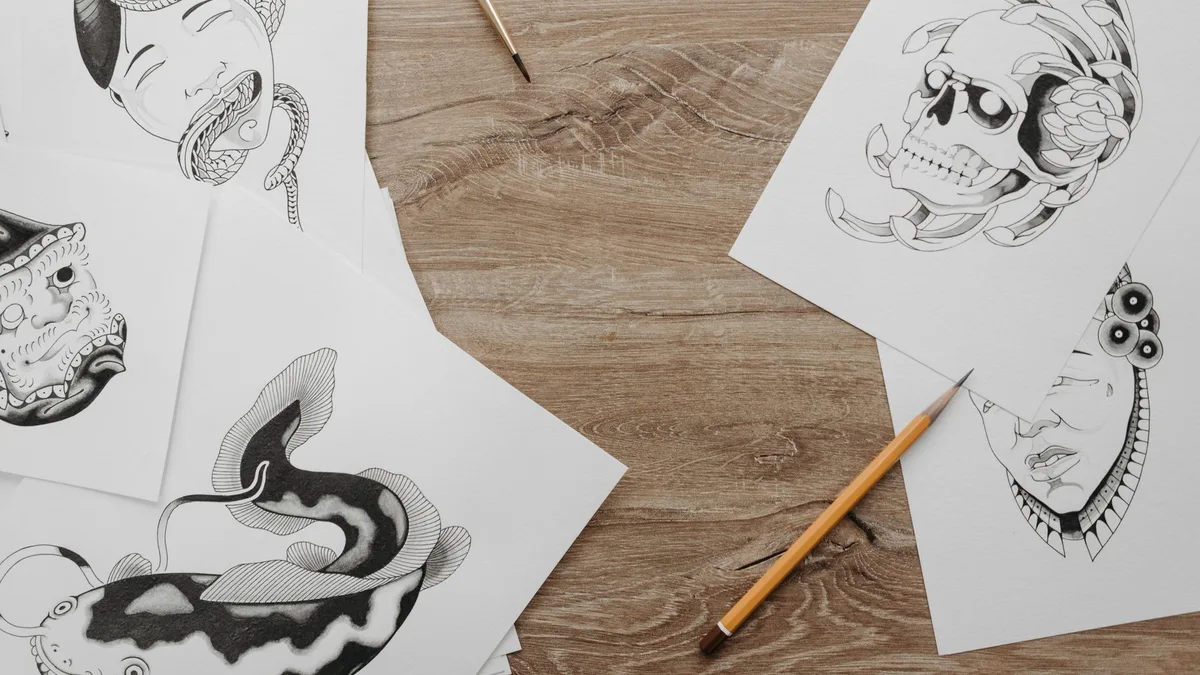 A flat-lay of hand-drawn logo sketches and design layouts on a desk