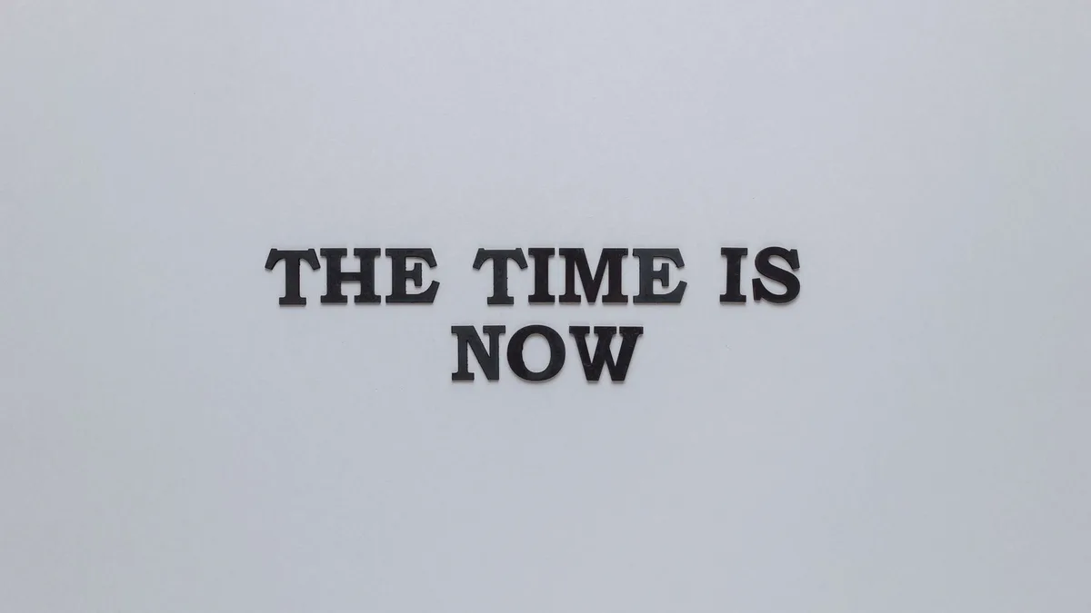A minimalist printed poster with a short bold quotation set on a plain grey background